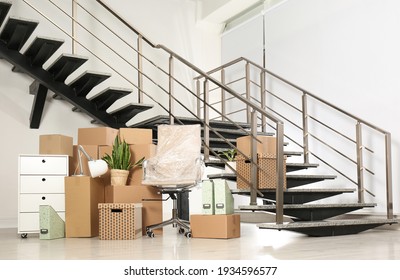 Cardboard Boxes And Packed Chair Near Stairs In Office. Moving Day