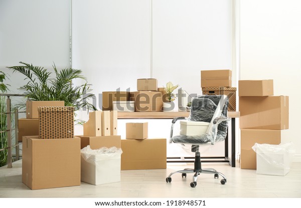 Cardboard\
boxes and packed chair in office. Moving\
day