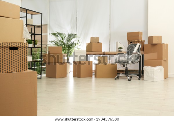 Cardboard\
boxes and packed chair in office. Moving\
day