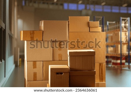 Cardboard boxes. Parcels in industrial building. Courier boxes of different sizes. Boxes for long-term storage. Industrial warehouse with parcels. Multi-tier pallet racks are blurred.