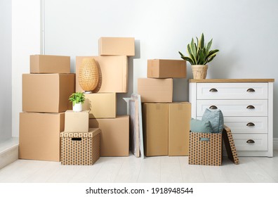 Cardboard boxes, potted plants and household stuff indoors. Moving day