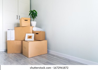 A lot of cardboard boxes with things to move. Check-in to a new apartment or office. Wall and closet in a new empty apartment. Copy space.