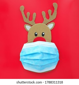 Cardboard Cutout Of Cute Reindeer Wearing A Face Mask. Covid During Christmas Season Concept.