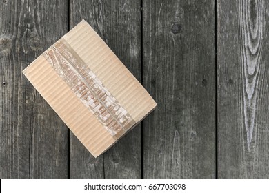 Cardboard Delivery Parcel Box Delivered To Doorstep On Old Wood Background