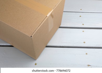 Cardboard delivery parcel box delivered to doorstep closeup
