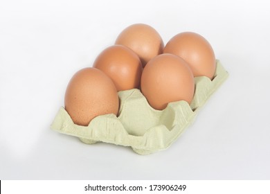 Cardboard egg box with five brown eggs isolated on white.