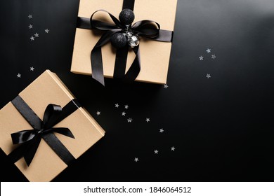 Cardboard gift boxes decorated black ribbon bows and confetti on black background. Christmas present, New Year gift box concept. - Powered by Shutterstock