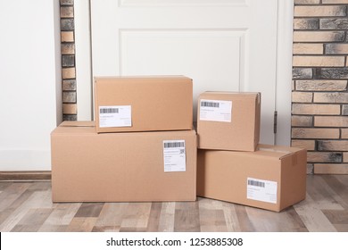 Cardboard Parcel Boxes On Floor Near Apartment Entrance. Mockup For Design