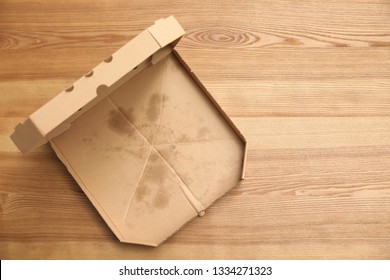 Cardboard Pizza Box On Wooden Background, Top View With Space For Text