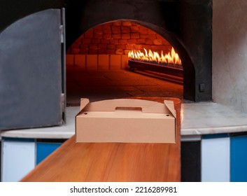 Cardboard Takeaway Food Box In Front Of Burning Stone Oven