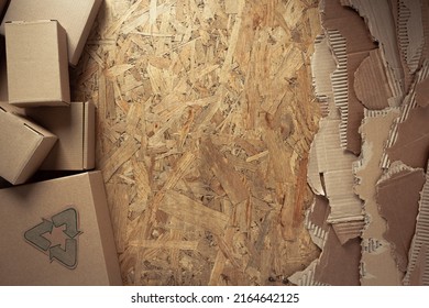 Cardboard Torn Edge At Chipboard Plywood Background Texture. Recycle Symbol And Cardboard Box From Recycled Paper