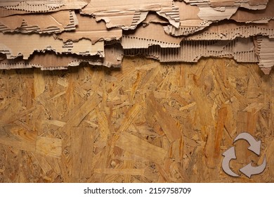 Cardboard Torn Edge And Recycle Symbol At Chipboard Plywood Background Texture. Brown Ripped Paper