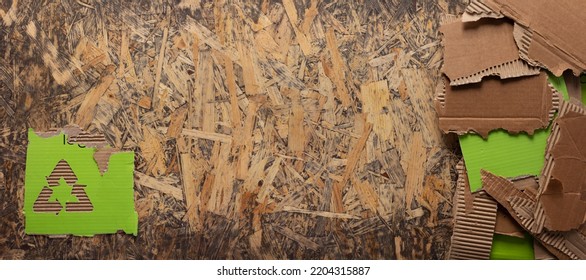 Cardboard Torn Edge And Recycle Symbol At Chipboard Plywood Background Texture. Brown Ripped Paper