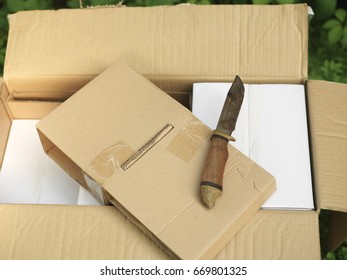 Cardboard Un Boxing With A Knife On The Top, Selective Focus Outdoor Closeup