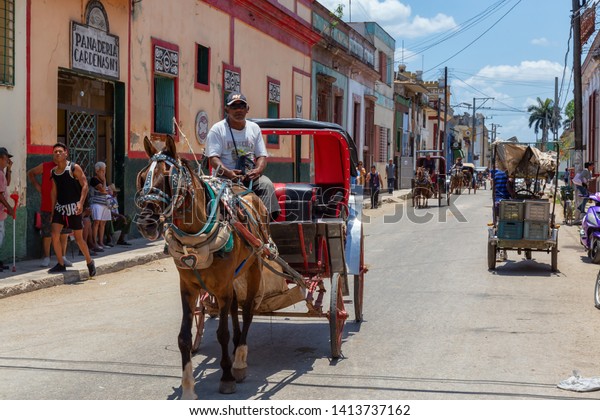 Cardenas,\
Cuba - May 11, 2018: Horse Carriage riding in the streets of an Old\
Cuban Town near Varadero during a sunny\
day.