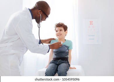 Cardiac Auscultation. Inspired Gay Male Doctor Staying While Using Stethoscope And Listening To Boy