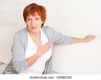 Cardiac Pain. Mature Woman Holds Her Heart