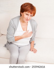 Cardiac Pain. Mature Woman Holds Her Heart