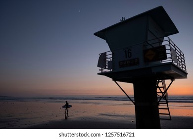 Cardiff by the Sea, California / USA 12/09/2018. A surfer walks past a life guard tower in the Southern California surf town of Cardiff by the Sea in San Diego.