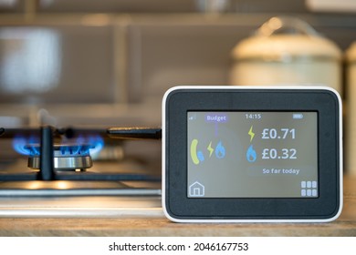Cardiff glamorgan Wales UK September 22 2021 selected focus household digital smart meter against a background of a gas flame on a cooker .