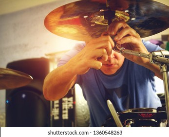 Cardiff, UK / 31st March 2019 : Drummer Setting Up His Kit And Tightening A Cymbal Screw In A Recording Studio.