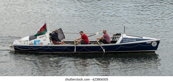 CARDIFF, UK - APRIL 14 2017 Talisker Whiskey Atlantic Challenge boat with crew. Rowers and coach training for Atlantic crossing on board ocean-going rowing boat on lake in Cardiff Bay, Wales