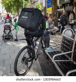 Cardiff, UK. August 2017. An Uber Eats Courier Waits To Receive An Order. Queen Street, Cardiff.