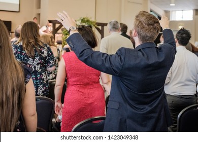 Cardiff, UK. July 2018. A Man Raising His Hands In Worship At A Charismatic Christian Church Meeting.