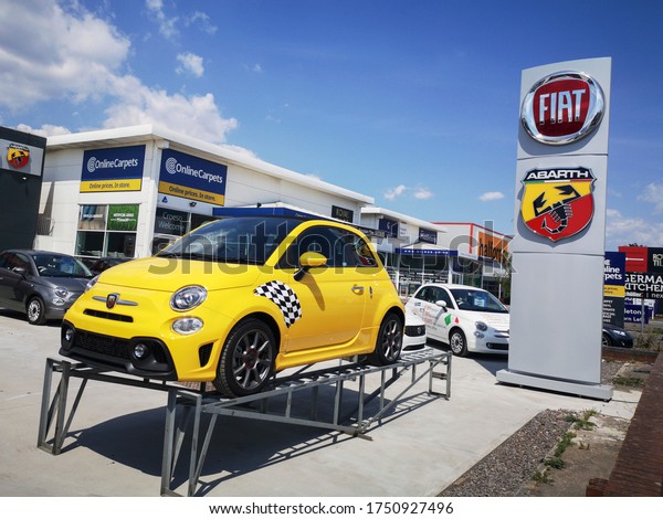 Cardiff, UK: June 02, 2020: Fiat\
500 on display with logo and Abarth sign on a dealership forecourt.\
