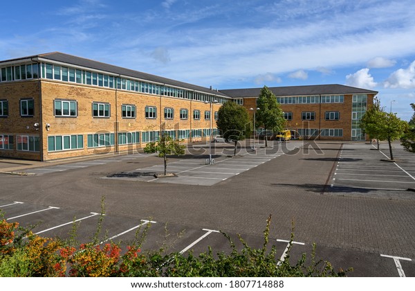 Cardiff, Wales - August 2020: Large office\
building with empty car park as staff work from home due to the\
coronavirus pandemic.