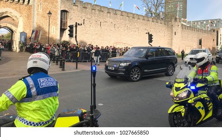 Cardiff, Wales - January 2018: Two Police Motorcycle Outriders Stopped In A City Street With A Vehicle Carrying  A Member Of The Royal Family In The Background