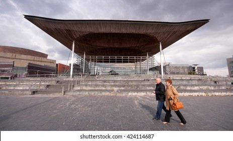 Cardiff, Wales - March 17, 2013: A Couple Walk Past The Welsh Parliament Building In Cardiff Bay.