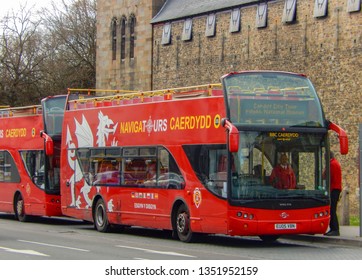 CARDIFF, WALES - MARCH 2019: Double decker tourist sightseeing buses parked in front of Cardiff Castle.