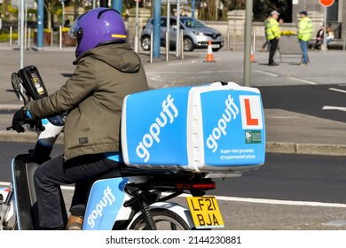 Cardiff, Wales - March 2022: Motorcycle courier for the Gopuff food delivery service driving through the centre of the city