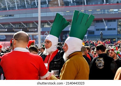 Cardiff, Wales - March 2022: Two Rugby Fans Waering Hats In The Shape Of The Leek Vegetable, Which Features In Welsh Tradition