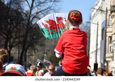 Cardiff, Wales - March 2022: Young Girl Sitting On Her Father's Shoulders Waving The Welsh Flag