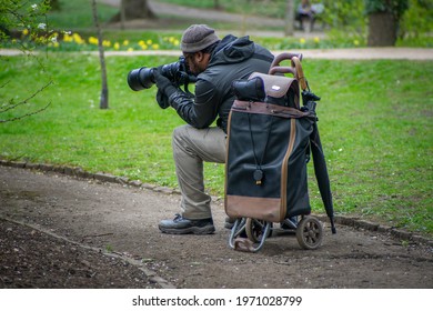 Cardiff, Wales, UK - 04.08.2021: A Black Male Photographer Takes Photos Of Wildlife In A Park, With A Telephoto Lens.