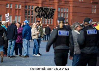 CARDIFF, WALES, UNITED KINGDOM - October 11, 2020 - A Protester Holds A Placard Reading ‘covid Is A Hoax’  During A Protest Against Coronavirus Lockdown Restrictions.