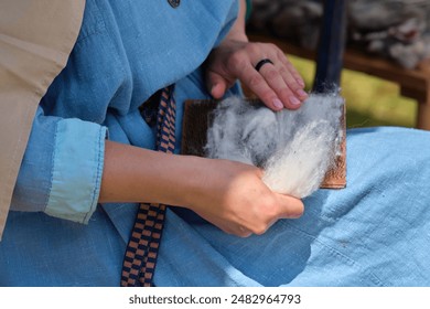 The carding of wool by hand is a historical craft technique that aligns the fibers for easier spinning. - Powered by Shutterstock