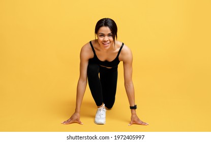 Cardio Training And Start. Happy Black Woman In Sports Uniform Ready To Run, Looking And Smiling To Camera Isolated On Yellow Background, Studio Shot. Marathon, Morning Workout, Jogging, Weight Loss