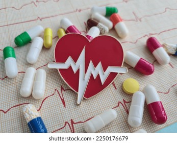 Cardiogram with red heart pills and cardiogram. Treatment of cardiovascular diseases concept