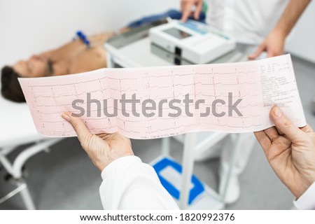 Cardiogram test, close-up of ECG report over mature male patient