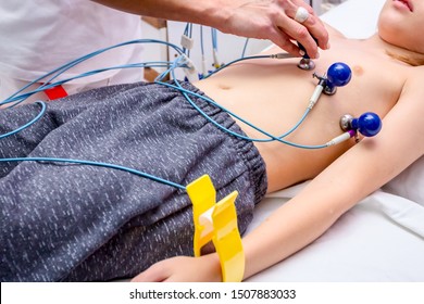 Cardiologist Is Attaching Vacuum Sensors To Child, Teenager Patient For Recording ECG Or EKG Cardiogram Test.