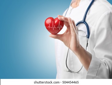 Cardiologist holding red heart with electrocardiogram. Cardiology concept.
