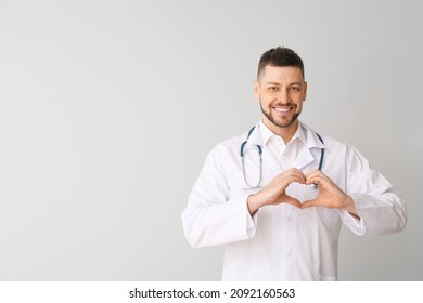 Cardiologist Making Heart With His Hands On Light Background