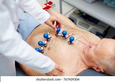 Cardiologist Putting Special Equipment On Chest Of Patient Before Making Ecg