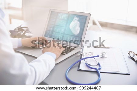 Cardiologist working with laptop at office. Health care concept.