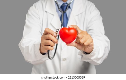 Cardiology Concept. Close-up Of Hand Doctor Holding A Red Heart Shape While Standing In The Hospital. Space For Text. Close-up Photo. Health And Medical Conceptual