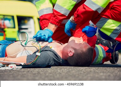 Cardiopulmonary resuscitation. Rescue team (doctor and a paramedic) resuscitating the man on the street. 