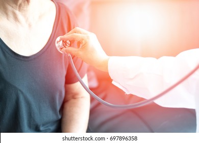 Cardiovascular Disease In The Elderly Concept. Professional Doctor Using Stethoscope With Female Elderly Patient To Listen Heart And Lung To Cure Chronic Disease.